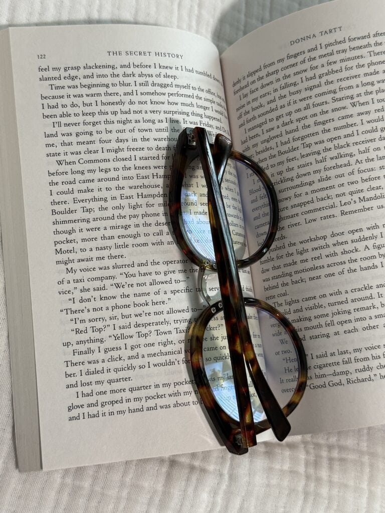 Open book with reading glasses on pages.