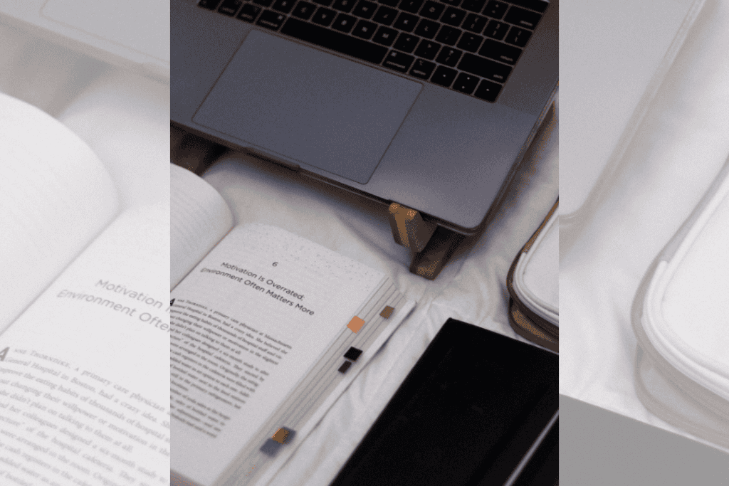 Photo of the book Atomic Habits by James Clear open and sitting in front of a laptop.