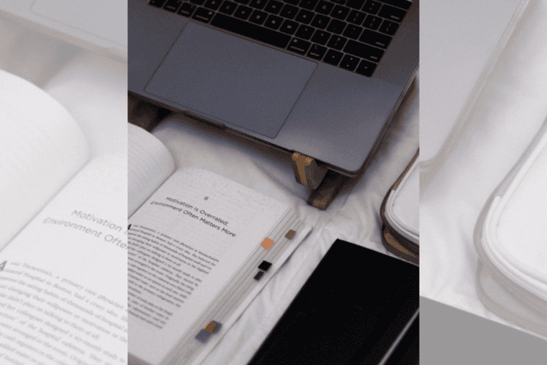 Photo of the book Atomic Habits by James Clear open and sitting in front of a laptop.